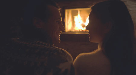 couple sitting in dark in front of fireplace