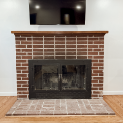 Original brick masonry fireplace with glass doors before installation of a wood insert in a Norristown, PA home